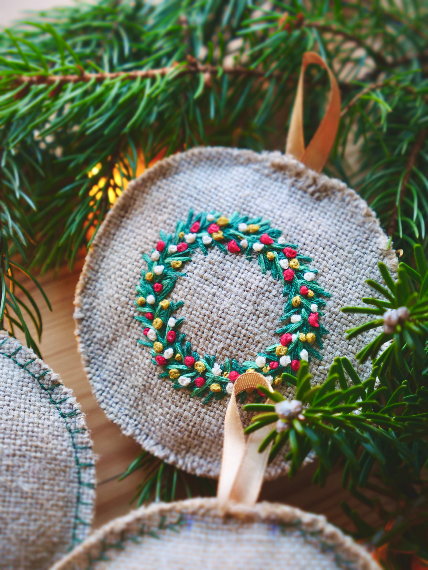 Brodert julekrans med grønne grener, røde og gylne bær